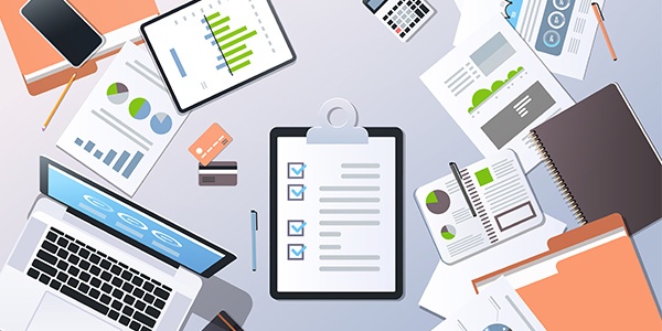 Graphic of laptop, clipboard, papers, and other office supplies