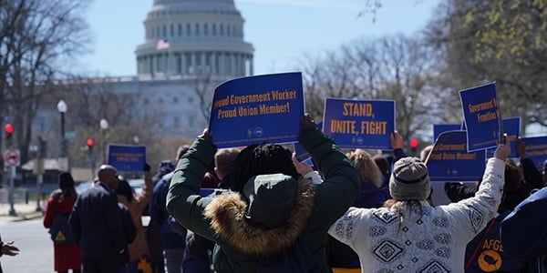 AFGE activists waving rally signs walking to the Capitol