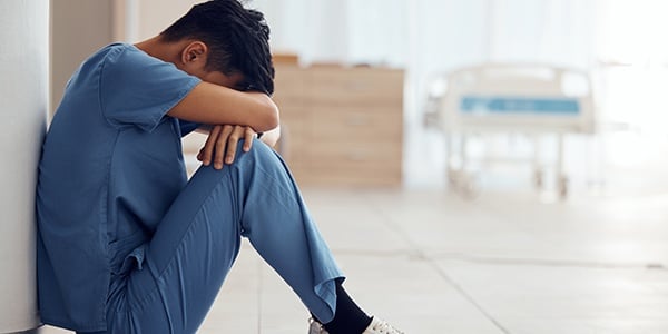 Health care worker sitting on the floor