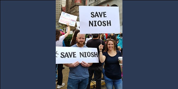 Two activists with Save NIOSH signs