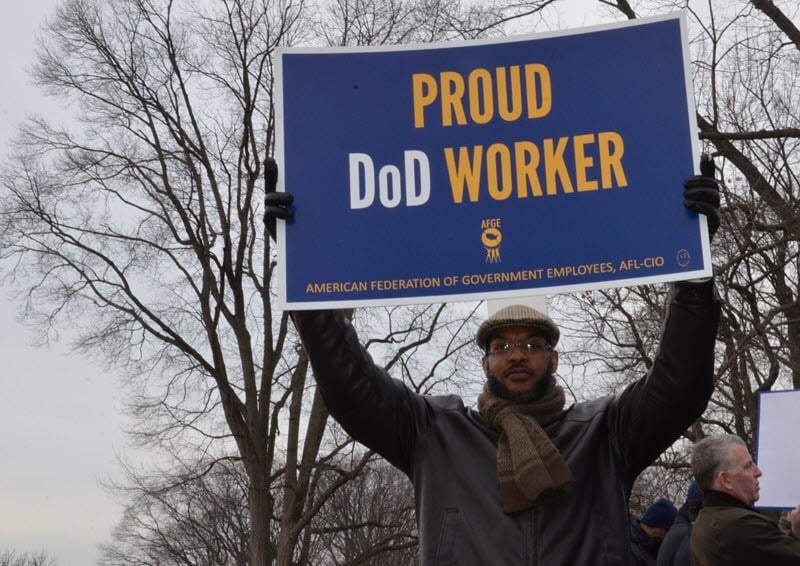 DoD Worker Holding a sign